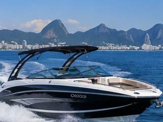 Lancha esportiva navegando com skyline do Rio de Janeiro ao fundo